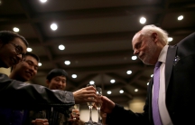 Man with champagne clinks glasses with three other men