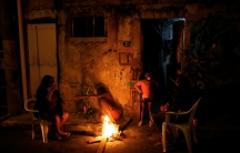 A family is pictured at the entrance of their house at a slum, or favela, in Rio de Janeiro
