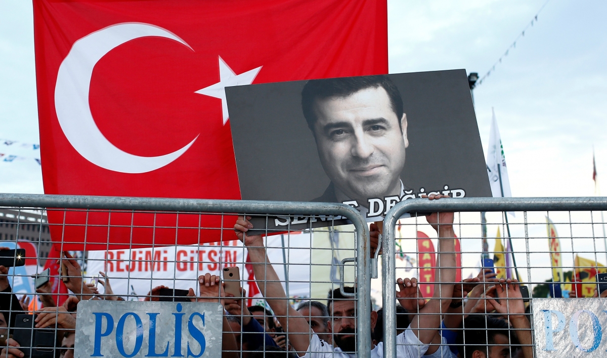 A supporter of Turkey's main pro-Kurdish Peoples' Democratic Party holds a portrait of their jailed former leader and presidential candidate Selahattin Demirtaş during a campaign event in Istanbul, Turkey, June 17, 2018.