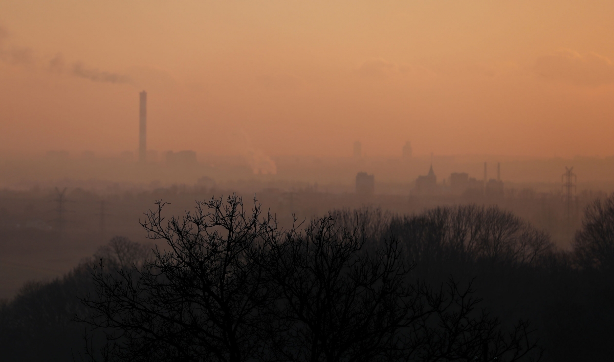 The tops of buildings are barely visible through a thick layer of smog.