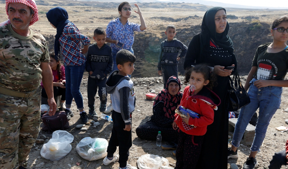 Displaced Kurds stuck at a border after a Turkish offensive in northeastern Syria, wait to try cross to the Iraqi side, at the Semalka crossing, next Derik city, Syria, on Oct. 21, 2019.