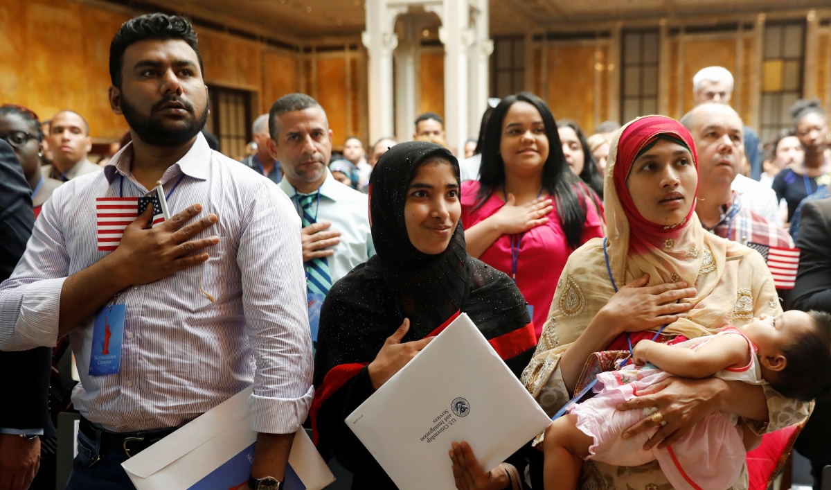New citizens stand during the National Anthem at a US Citizenship and Immigration Services (USCIS) naturalization ceremony at the New York Public Library in Manhattan, New York, on July 3, 2018.