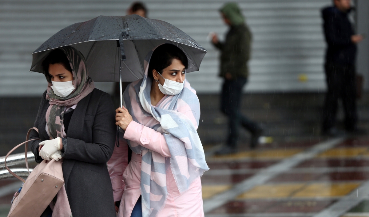 Iranian women wear protective masks to prevent contracting coronavirus as they walk in the street in Tehran, Iran, Feb. 25, 2020.