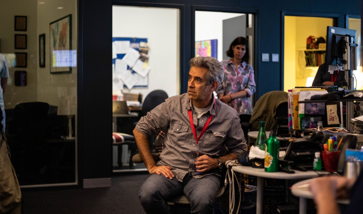 Marco Werman is shown looking to his right and wearing a red lanyard.