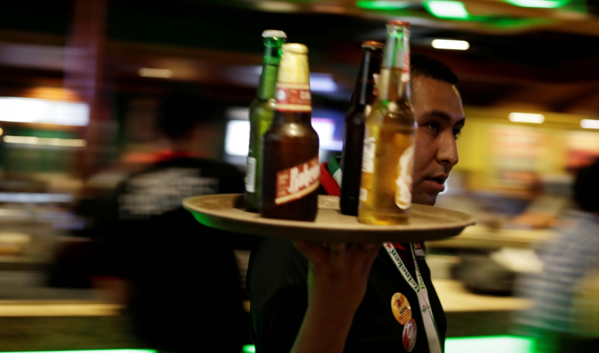 A waiter carries a round tray with bottles of Mexican beer at a bar in Ciudad Juarez, Mexico, on June 20, 2017.