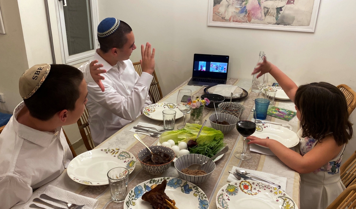 Three siblings in Mevasseret Zion, near Jerusalem, wave to their their grandmother in Haifa as she joins their Passover Seder via Zoom application as Israel takes stringent steps to contain the coronavirus (COVID-19) April 8, 2020.