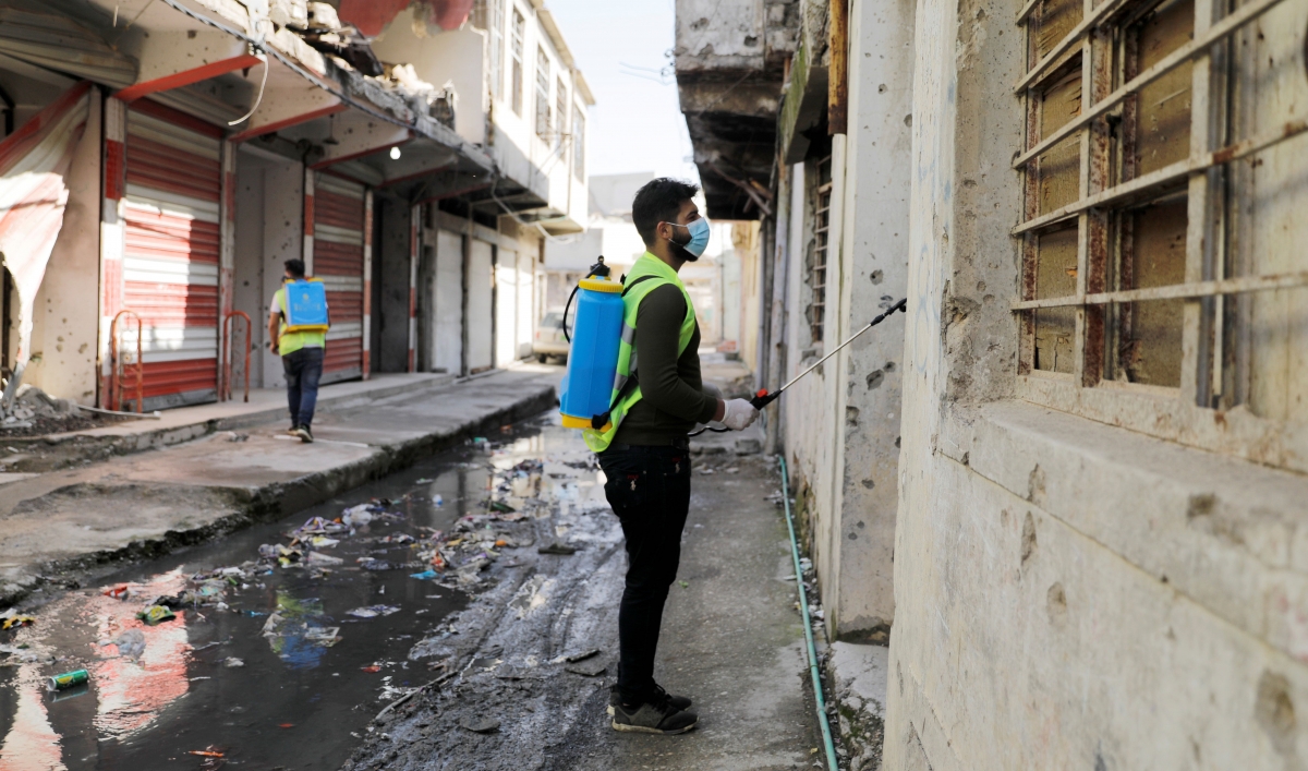 Iraqi young volunteers spray with disinfectants to combat an outbreak of coronavirus during a curfew imposed by Iraqi authorities, in the old city of Mosul, Iraq, March 15, 2020.
