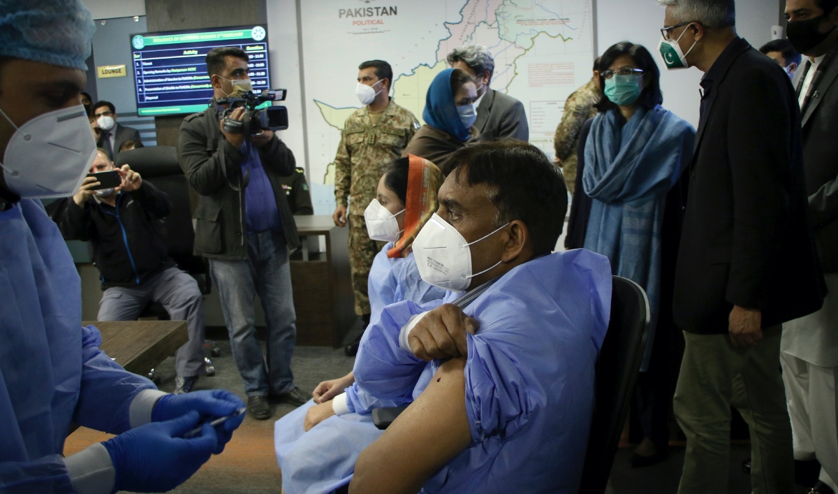 A health worker administers the Chinese Sinopharm COVID-19 vaccine to his colleague while the prime minister's adviser on health issues Faisal Sultan, second right, and other officials watch during a ceremony to start the vaccination campaign in Islamabad