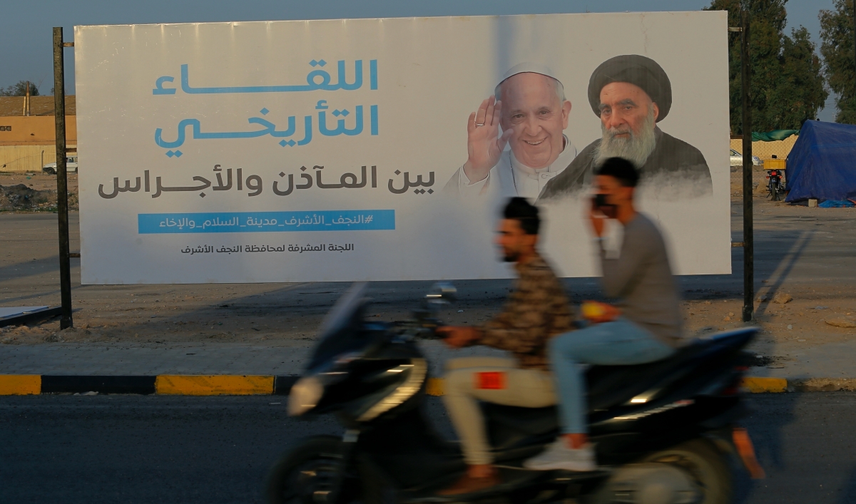 Iraqis put up a poster announcing the upcoming visit of Pope Francis and a meeting with a revered Shiite Muslim leader, Grand Ayatollah Ali al-Sistani, right, in Najaf, Iraq, March 4, 2021.