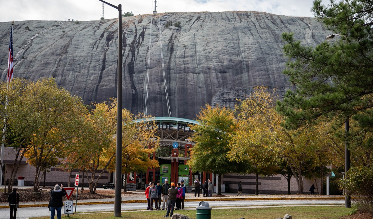 Tourists at the mingling with Stone Mountain and colorful trees in the background