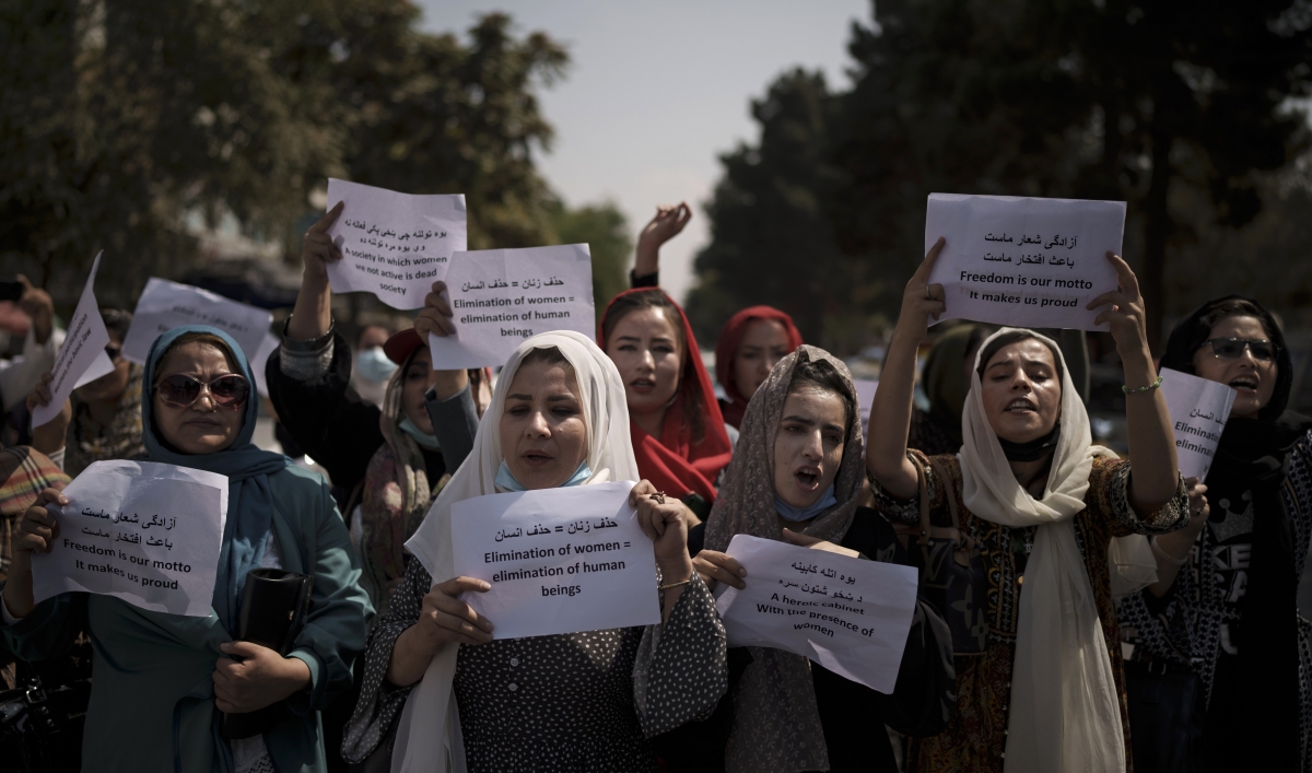 Afghan women march and hold signs in rally