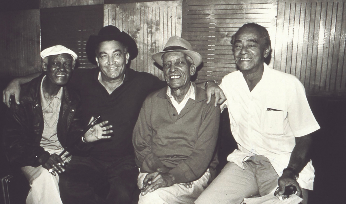 A black and white photo of Buena Vista Social Club members Ibrahim Ferrer, Eliades Ochoa, Comapy Segundo and Puntillita Licea.