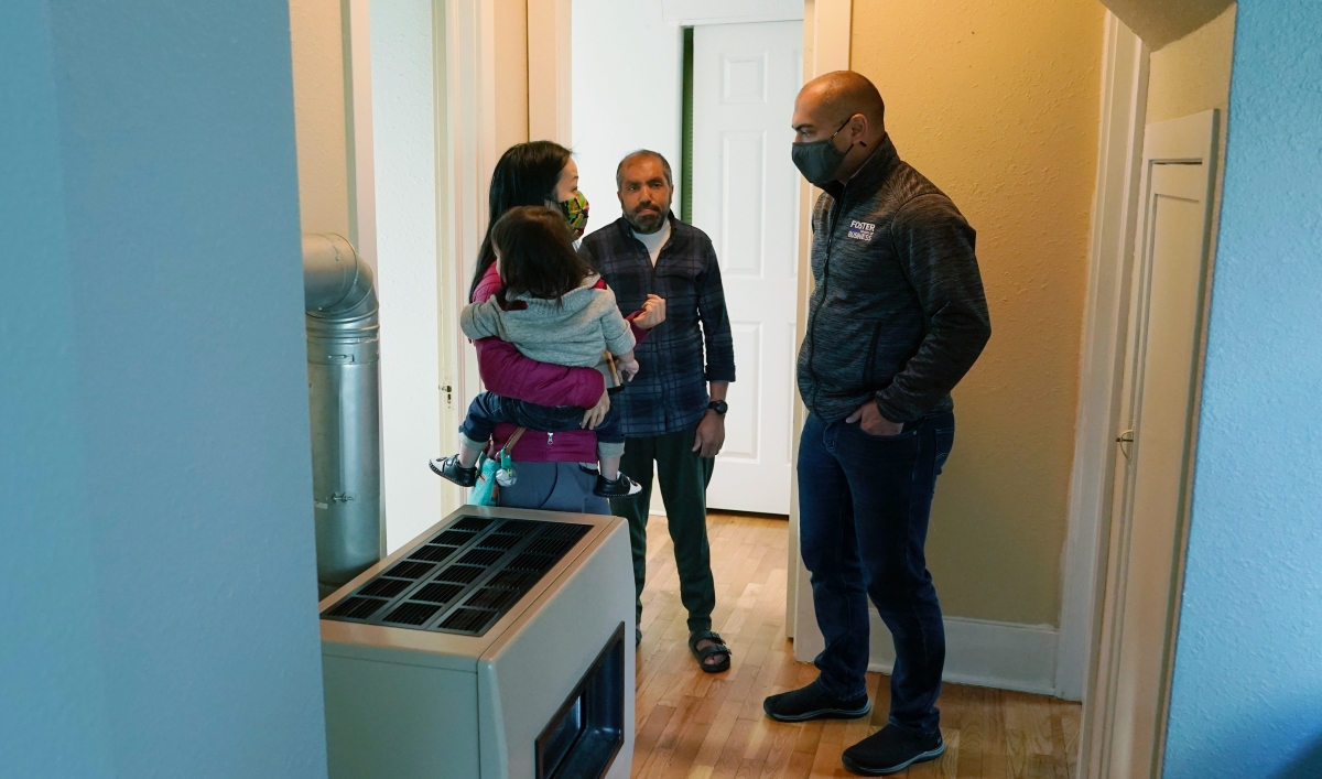 Thuy Do, left, and her husband, Jesse Robbins, right, talk with Abdul, center, Sept. 20, 2021,