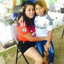 A woman sitting holds young girl