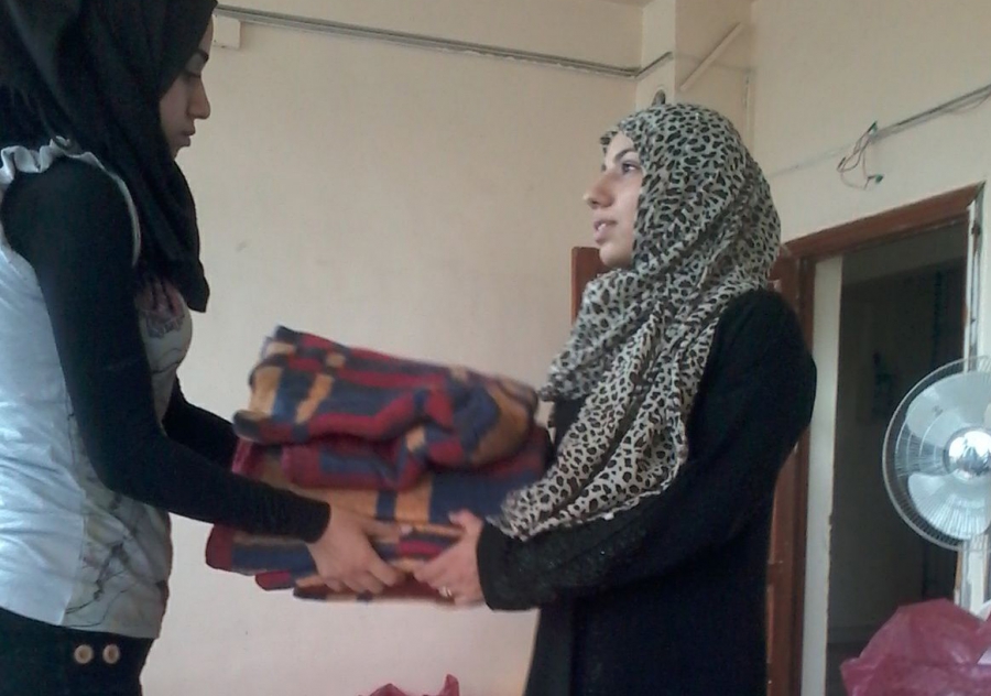 A Questscope volunteer gives a blanket to a woman who fled her home near the Syrian city of Hama after fighting there earlier this year. A Questscope volunteer gives a blanket to a woman who fled her home near the Syrian city of Hama after fighting there earlier this year.