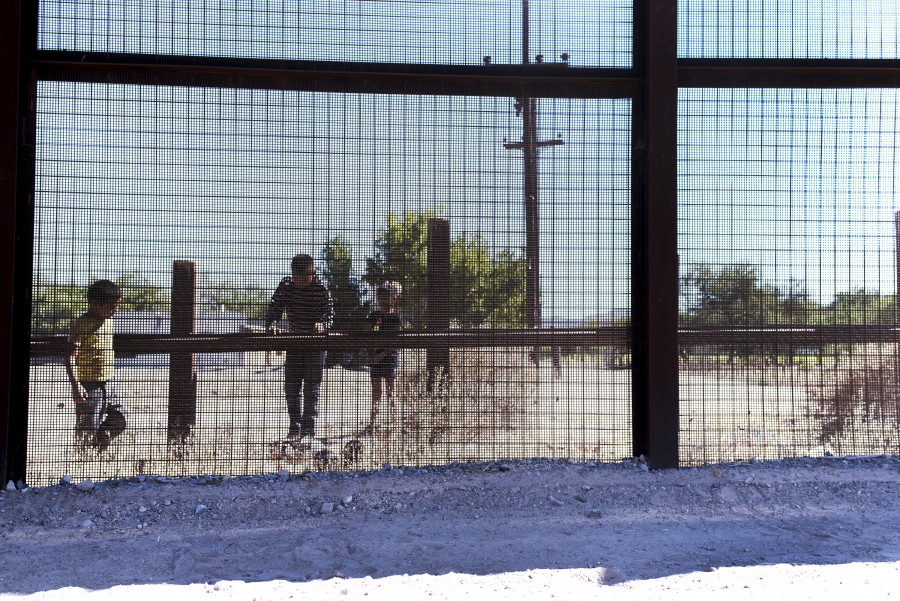 Mesh fencing with children behind, looking onto US side