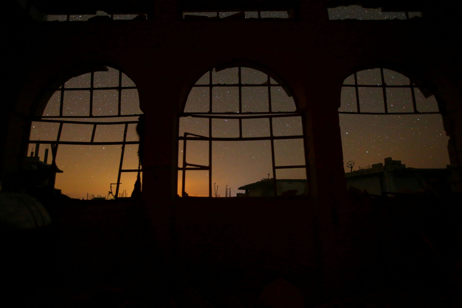 The night sky is seen through damaged windows in the rebel-controlled town of Binnish in Idlib province. The night sky is seen through damaged windows in the rebel-controlled town of Binnish in Idlib province.