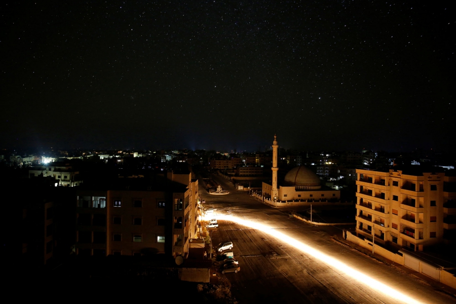A vehicle drives past a mosque at night in Idlib, Syria. A vehicle drives past a mosque at night in Idlib, Syria.