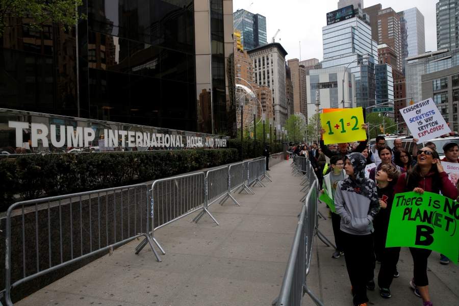 People walk past Trump International Hotel and Tower during the Earth Day 'March For Science NYC' demonstration to coincide with similar marches globally in New York City, April 22, 2017.