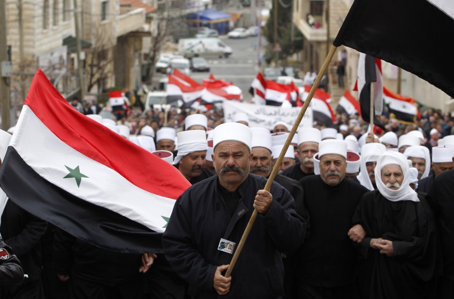 Members of the Druze community hold Syrian flags during a rally in the Druze village of Majdal Shams in the Golan Heights, Feb. 14, 2013.