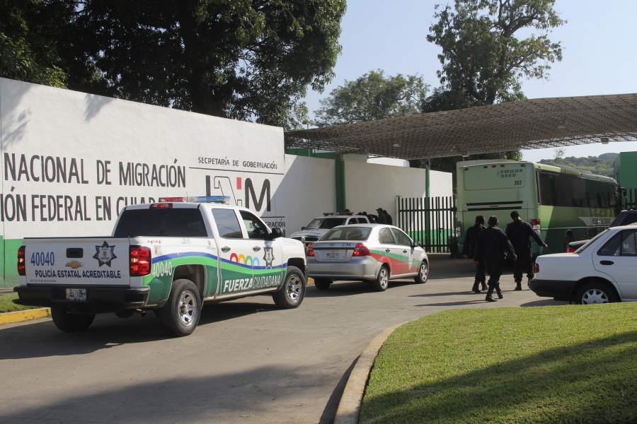 Trucks and police officers in front of small building