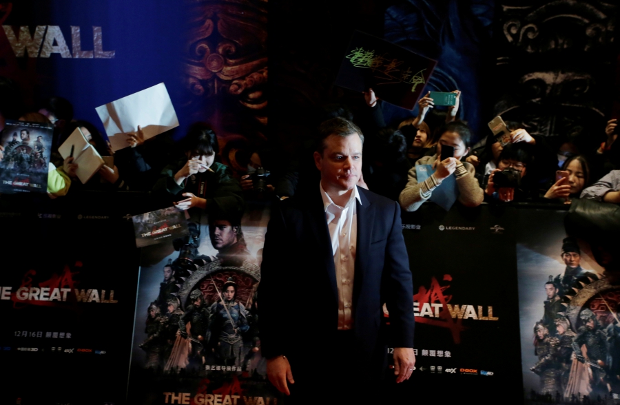 Man in front of posters and photographers