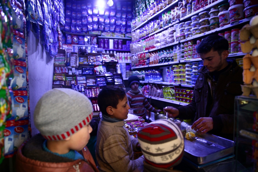 Boys buy goods from a grocery shop in the rebel-held, besieged Damascus suburb of Eastern Ghouta, Syria, Feb. 12, 2017.