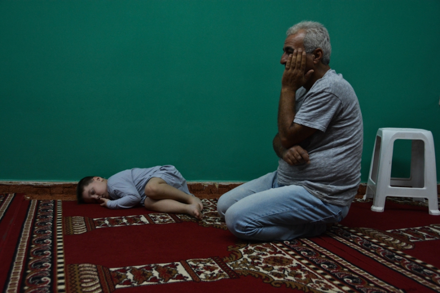 Mohammad, a 5-year-old boy from Syria, takes a nap before the night prayer on the floor of a makeshift mosque in the Attiki neighborhood in Athens. Mohammad, a 5-year-old boy from Syria, takes a nap before the night prayer on the floor of a makeshift mosque in the Attiki neighborhood in Athens.