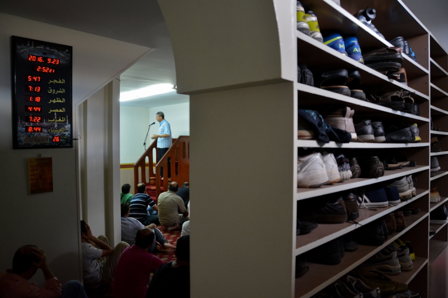 An imam is preaching moments before the Jumu'ah (Friday prayer) begins at a makeshift mosque in Metaxourgio. An imam is preaching moments before the Jumu'ah (Friday prayer) begins at a makeshift mosque in Metaxourgio.