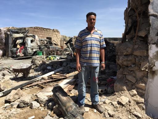 Ayman al-Sanabani stands outside the wreckage of his family's home. Ayman al-Sanabani stands outside the wreckage of his family's home.