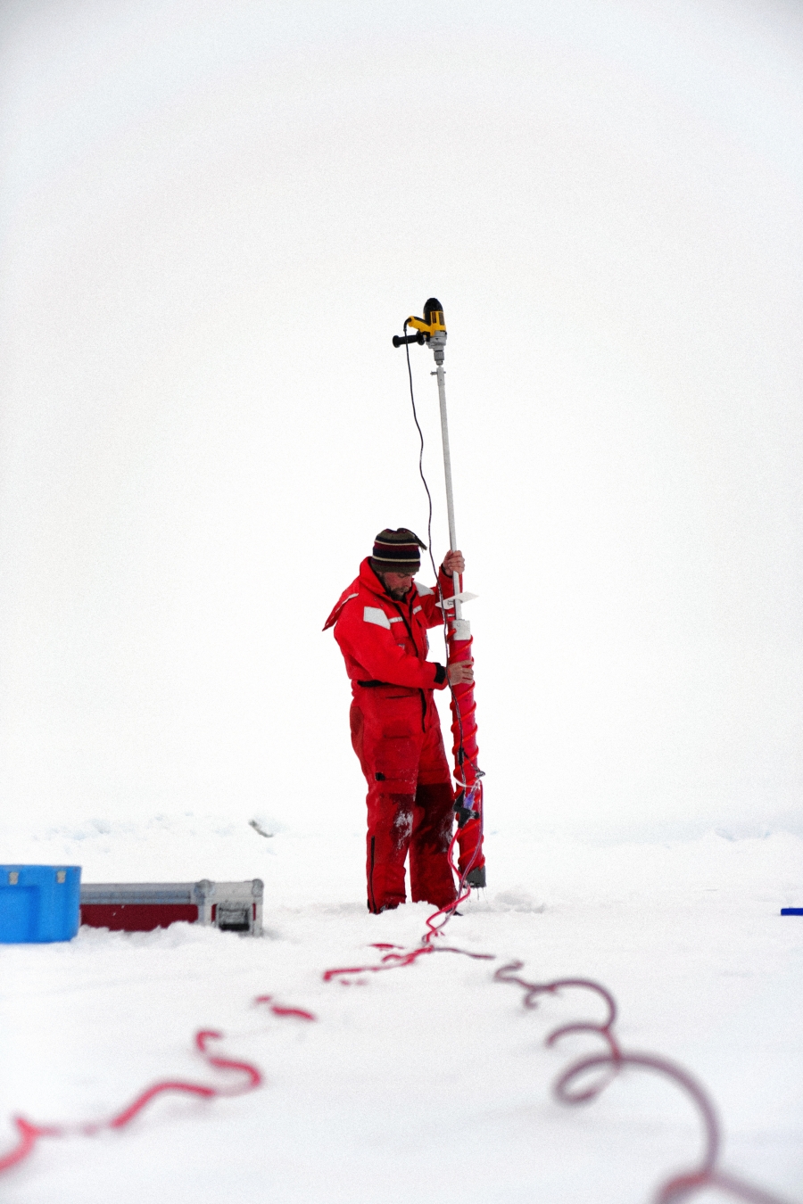 Chris Chris Polashenski uses an electric drill to core out a sample of sea ice. He uses the cores to investigate the tiny cracks in the ice that may or may not allow water to drain from melt ponds