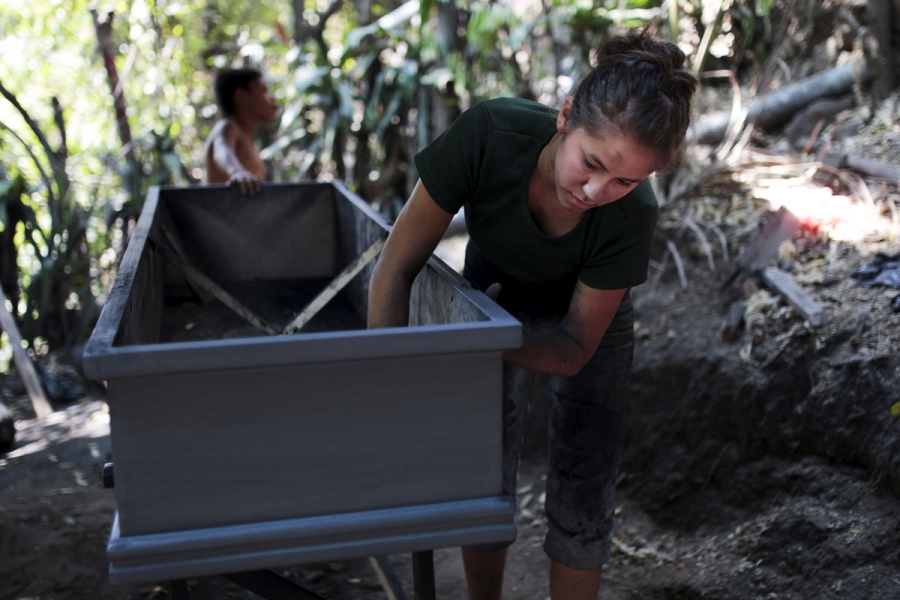 A worker applies sealant to a coffin at El Nuevo Renacer factory in Jucuapa. A worker applies sealant to a coffin at El Nuevo Renacer factory in Jucuapa.