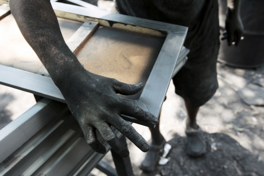 A worker applies sealant to a coffin at El Nuevo Renacer factory in Jucuapa. A worker applies sealant to a coffin at El Nuevo Renacer factory in Jucuapa.
