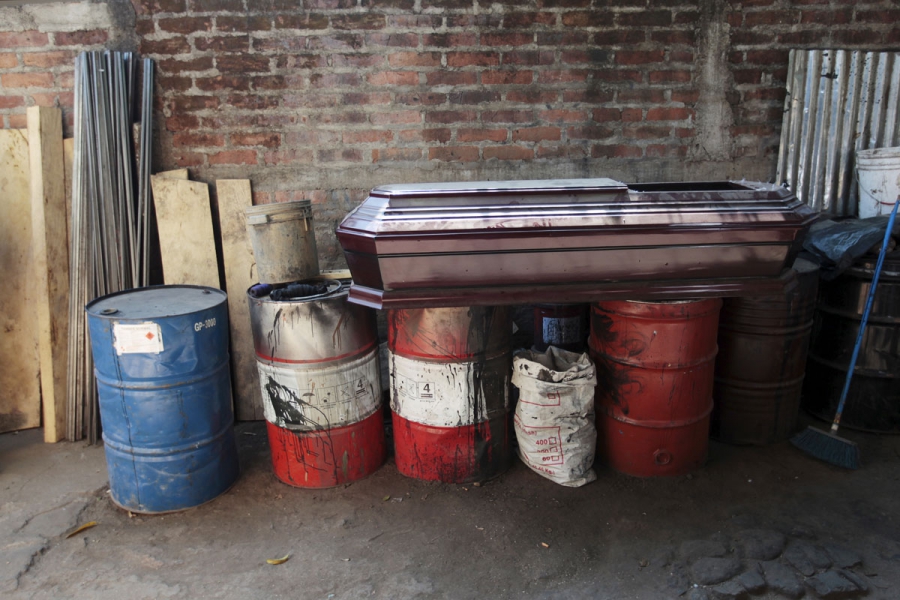 A coffin lies on barrels at El Nuevo Renacer factory in Jucuapa. A coffin lies on barrels at El Nuevo Renacer factory in Jucuapa.