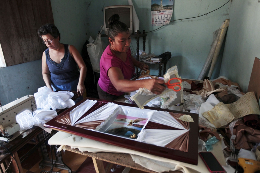 Women work on details of a coffin at El Nuevo Renacer factory in Jucuapa. Women work on details of a coffin at El Nuevo Renacer factory in Jucuapa.