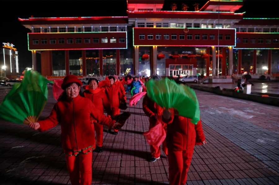 Women participate in a group dance exercise close to the Yalu River