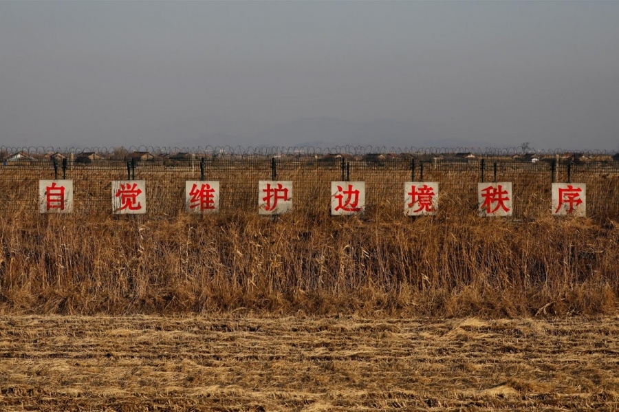 A sign reading, "Take the initiative to preserve order along the border,"