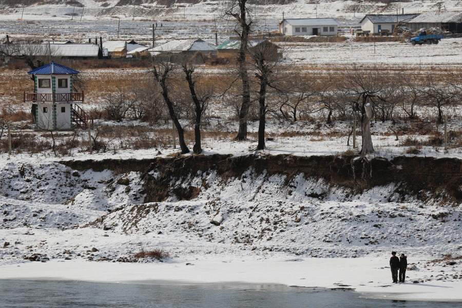 North Koreans are photographed from the Chinese side of the border