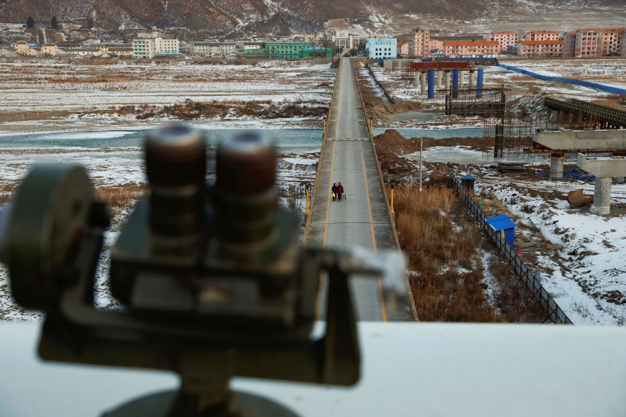Women, photographed from the Chinese side of border, are seen from a viewing point used by tourists to look into North Korea,