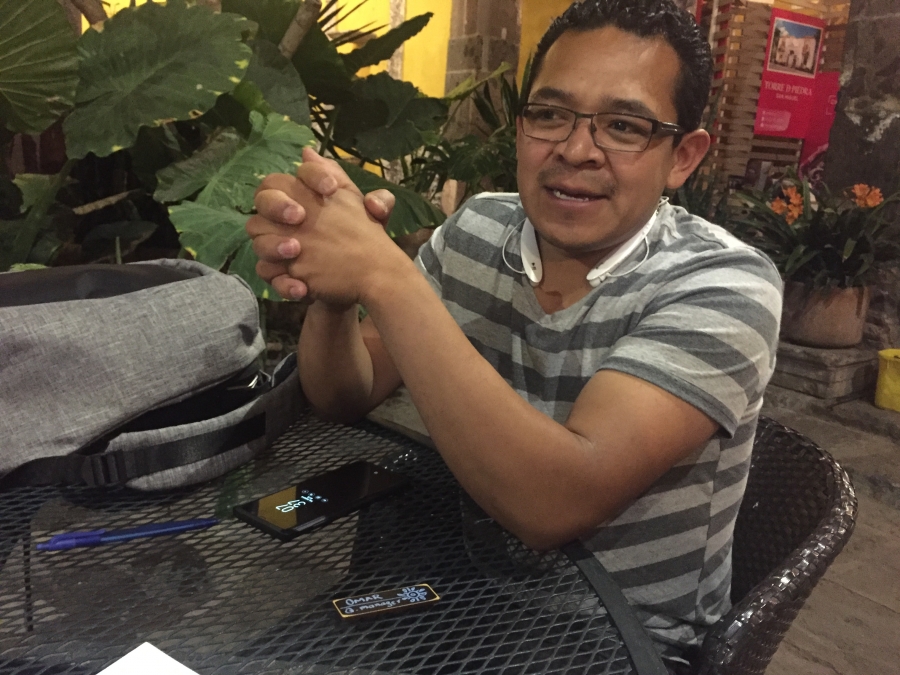Man sitting at table outdoors, with phone in front of him