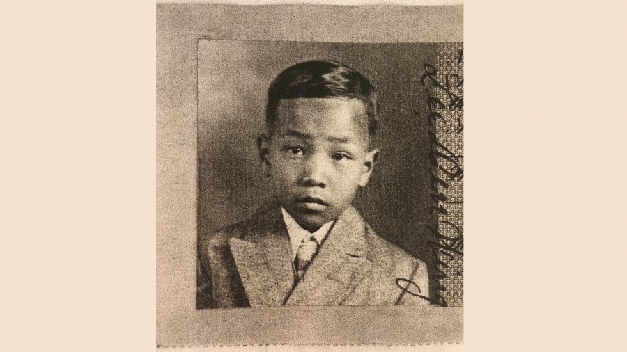 sepia toned image of young boy, with some damage to photo around edges