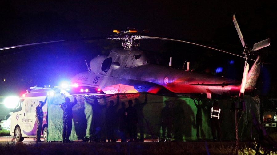 Rescued schoolboys are moved from a military helicopter to an awaiting ambulance at a military airport in Chiang Rai, Thailand, July 9, 2018. A military helicopter is shown in a photograph taken at night in Chiang Rai, Thailand.
