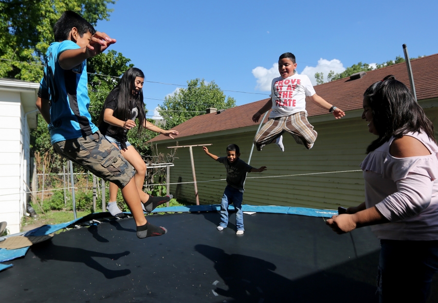 Children jump on trampoline outdoors