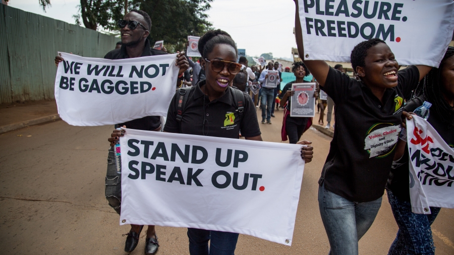Men and women took to the streets of Kampala to stand up for women's rights. Men and women are walking in the streets of Kampala holding placards with messages in support of women's rights.