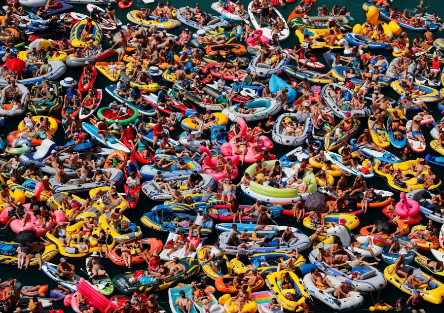 People on inflatable boats enjoy the sun as they watch the Red Bull Cliff Diving competition on Lake Lucerne in Sisikon, Switzerland. People on inflatable boats enjoy the sun as they watch the Red Bull Cliff Diving competition on Lake Lucerne in Sisikon, Switzerland.