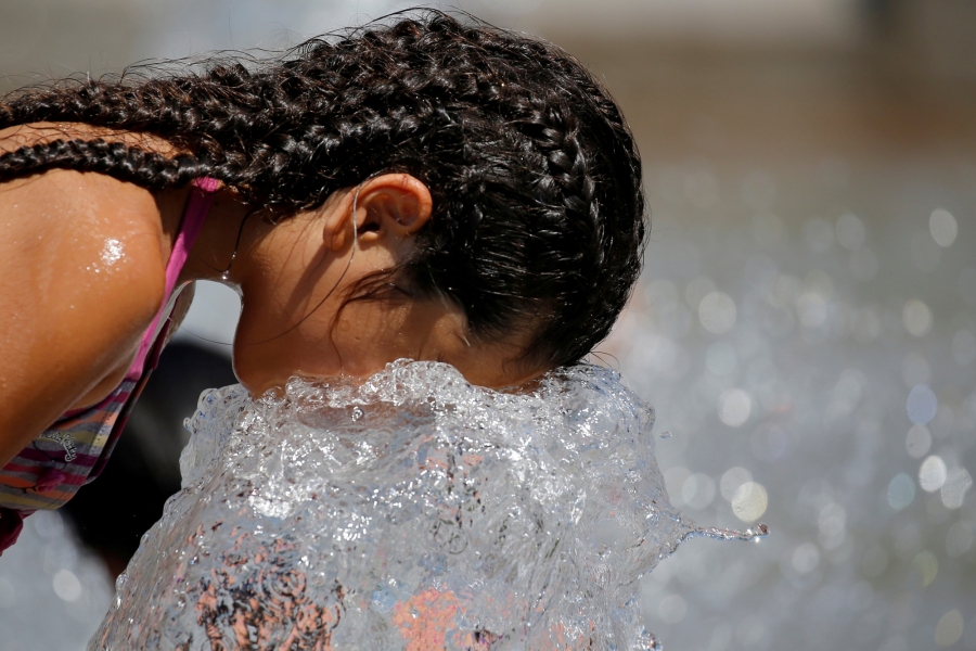 A child cools off in a fountain as a summer heat wave with high temperatures continues in Paris. A child cools off in a fountain as a summer heat wave with high temperatures continues in Paris.