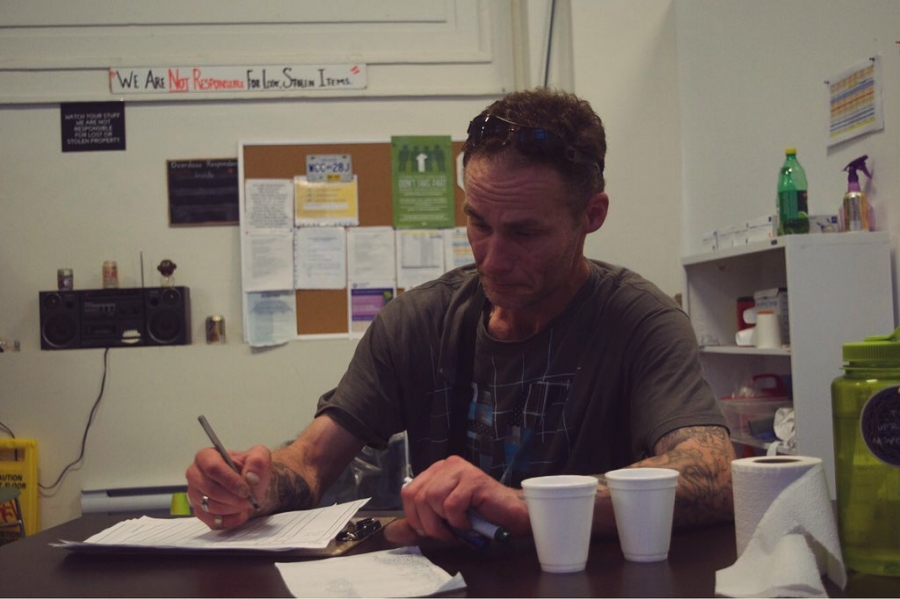 a man in a grey t-shirt writing