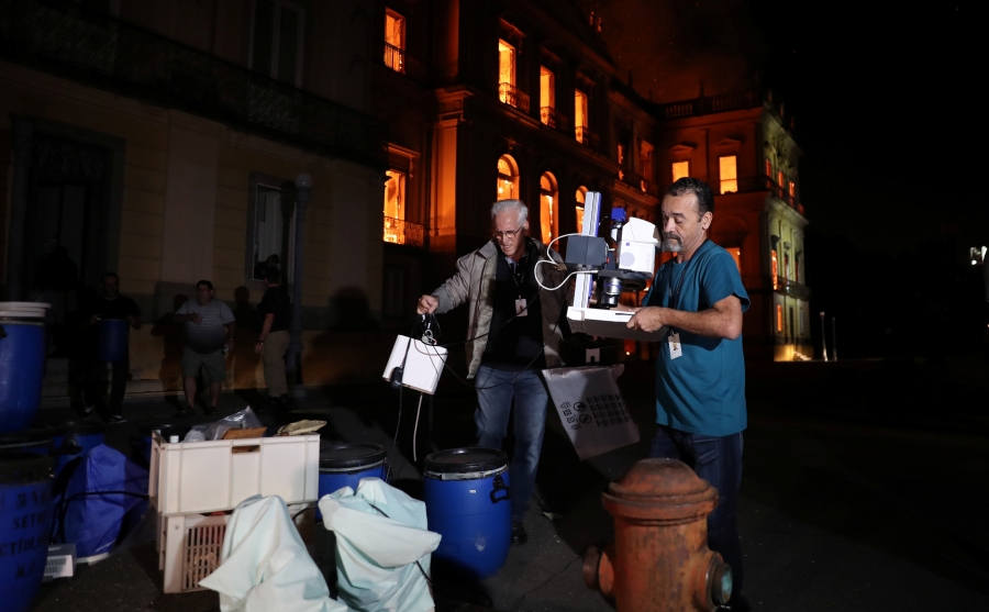 People rescue items during a fire