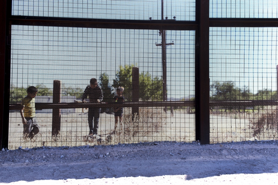 Mesh fencing with children behind, looking onto US side