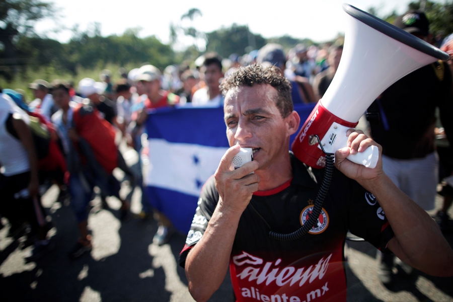 Central American migrants shout slogans as they walk along the highway near the border with Guatemala, while they continue their journey trying to reach the US, in Tapachula, Mexico, Oct. 21, 2018. Central American migrants shout slogans and one man spoke into a megaphone.